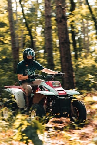 atv riding through trees in mountain forest